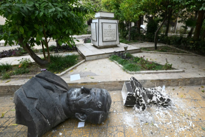 A broken statue of late Syrian president Hafez al-Assad lies outside the Baath party offices in Damascus