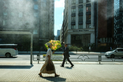 A woman with an umbrella walks in the scorching sun in Tokyo on September 1 - Philip FONG (AFP)
