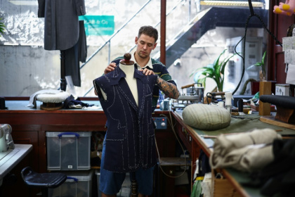 Apprentice tailor Henry adjusts a jacket at Henry Poole & Co on London's Savile Row, where competition for apprenticeships is stiff - HENRY NICHOLLS (AFP)