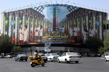 Iranians drive next to a billboard displaying pictures of nuclear scientists, centrifuges and a sentence reading in Farsi 'Science is the power' - - (AFP)