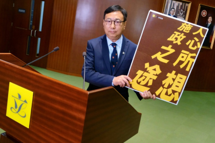 Lawmaker Tik Chi-yuen holds a sign reading "the will of the people, the path of governance" - Tommy WANG (AFP)