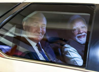 In this pool photograph distributed by the Russian state agency Sputnik, Russia's President Vladimir Putin and Indian Prime Minister Narendra Modi look out from a car prior to an informal dinner at Modi's residence - Alexander KAZAKOV (AFP)