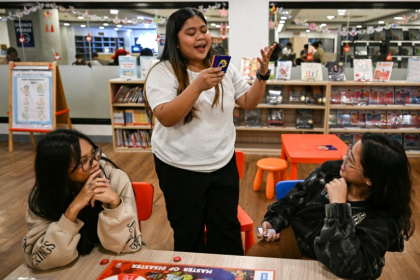 Participants play Master of Disaster, a board game about disaster preparedness, at a library in Valenzuela, Metro Manila - Jam STA ROSA (AFP)