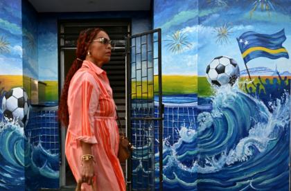 A woman walks past a mural depicting a football and the flag of Curacao in Willemstad, capital of the Dutch Caribbean island which is gripped by World Cup fever - Raul ARBOLEDA (AFP)