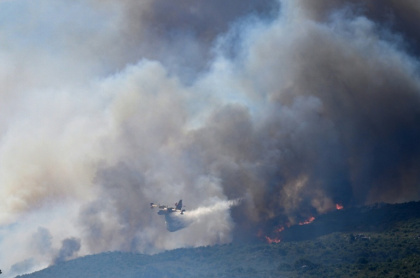 A French civil protection service plane drops water on a huge forest fire in the Pyrenees - Matthieu RONDEL (AFP)